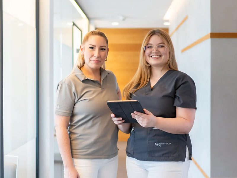 Zwei Mitarbeiterinnen mit Tablet im Praxisflur