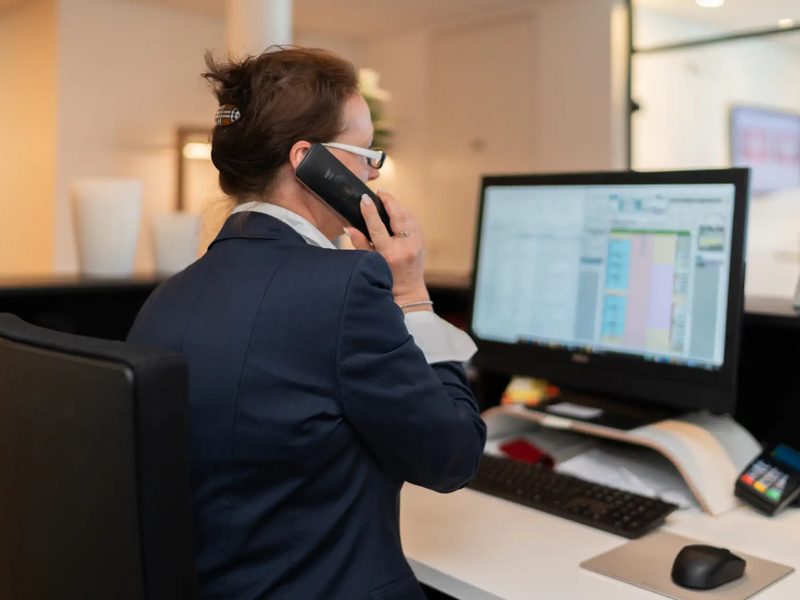 Mitarbeiterin telefoniert am Empfang