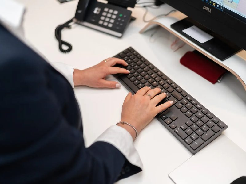 Hände an einer Tastatur am Empfang