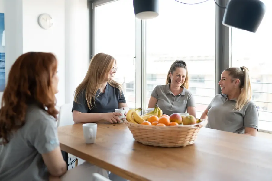 Vier Kolleginnen in der Pause am Tisch